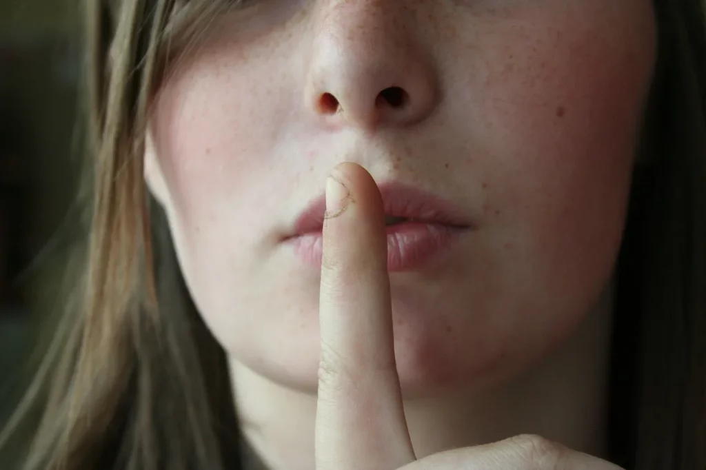 Woman shh finger on lips right to remain silent KPA Lawyers